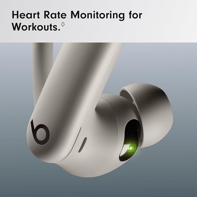 Powerbeats Pro 2 earbuds placed next to a phone and gym equipment.